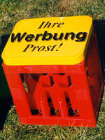 Ein gelber Modell-Getränkekastensitz 
mit der Aufschrift: Ihre Werbung Prost! 
Unser Einführungsangebot für Sie